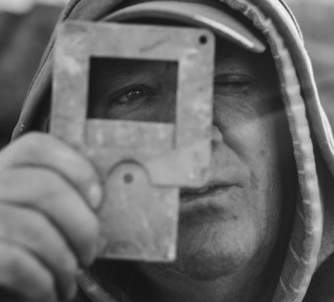 Dennis Doyle, plein air painter, looking through his paint-box viewfinder